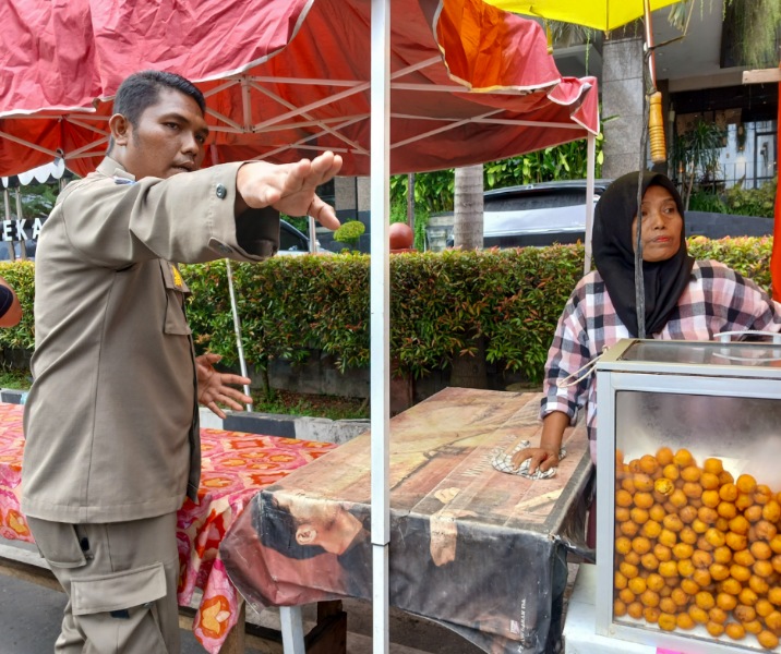 Petugas Satpol PP Pekanbaru memperingatkan pedagang takjil agar tak berjualan di bahu jalan. Foto: Surya/Riau1.