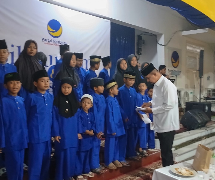 Petinggi DPW Partai Nasdem Riau menyerahkan santunan kepada anak yatim piatu dalam acara buka bersama, Sabtu (28/2/2026). Foto: Surya/Riau1.