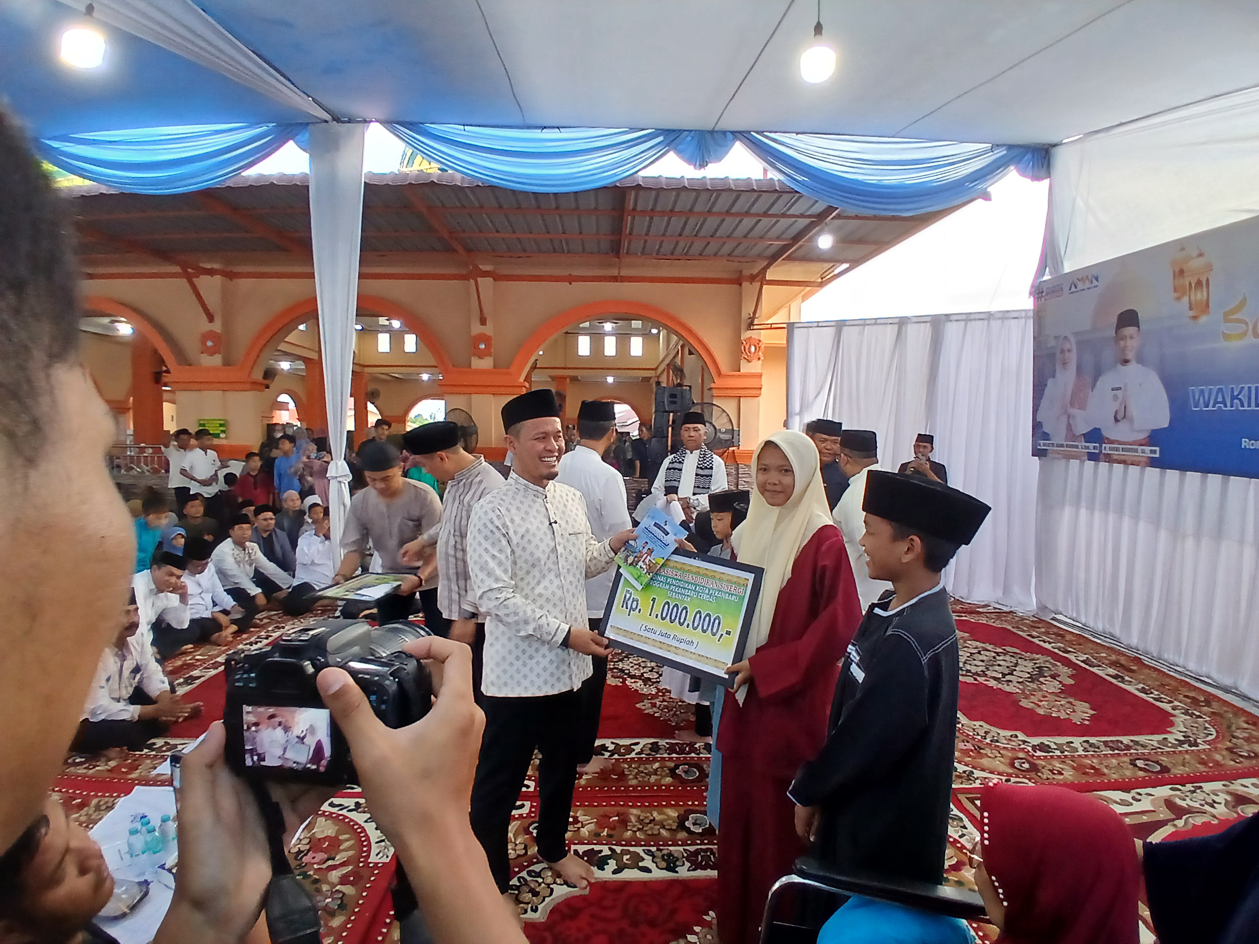 Wali Kota Pekanbaru Agung Nugroho memyerahkan bantuan kepada pelajar SMP saat Safari Ramadan di Masjid Ridho Ilahi di Rumbai Timur, Kamis (5/3/2026). Foto: Surya/Riau1.