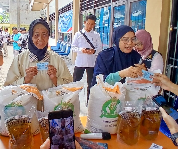 Warga Kelurahan Kota Tinggi dan Simpang Empay Kecamatan Pekanbaru Kota menerima bantuan beras dan minyak goreng dari Bulog. Foto: Surya/Riau1.