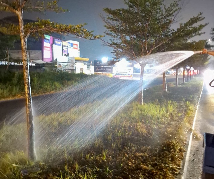 Petugas DLHK Pekanbaru saat menyiram tanaman yang tumbuh median jalan. Foto: Istimewa.
